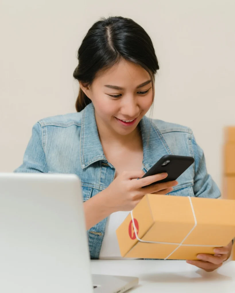 Online store owner checking an order on her phone before packing it